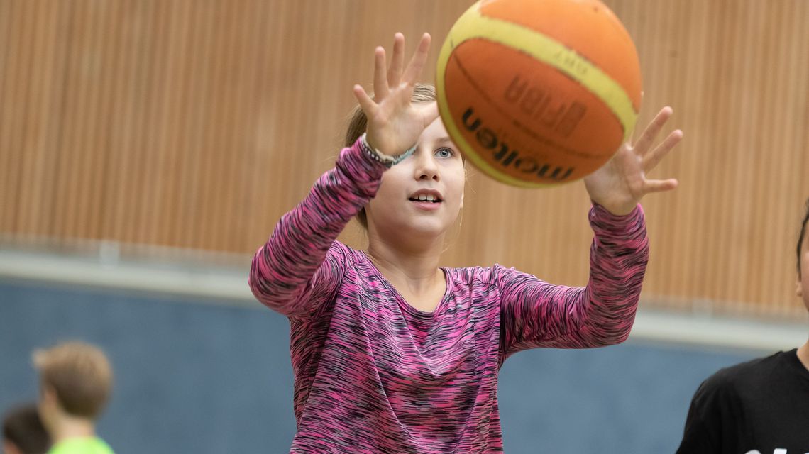 Eine Schülerin spielt Basketball