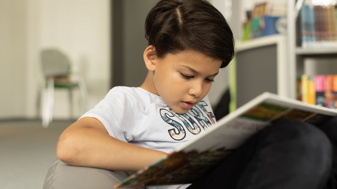 Ein Schüler sitzt im Sitzsack und liest ein Buch im Leseturm.