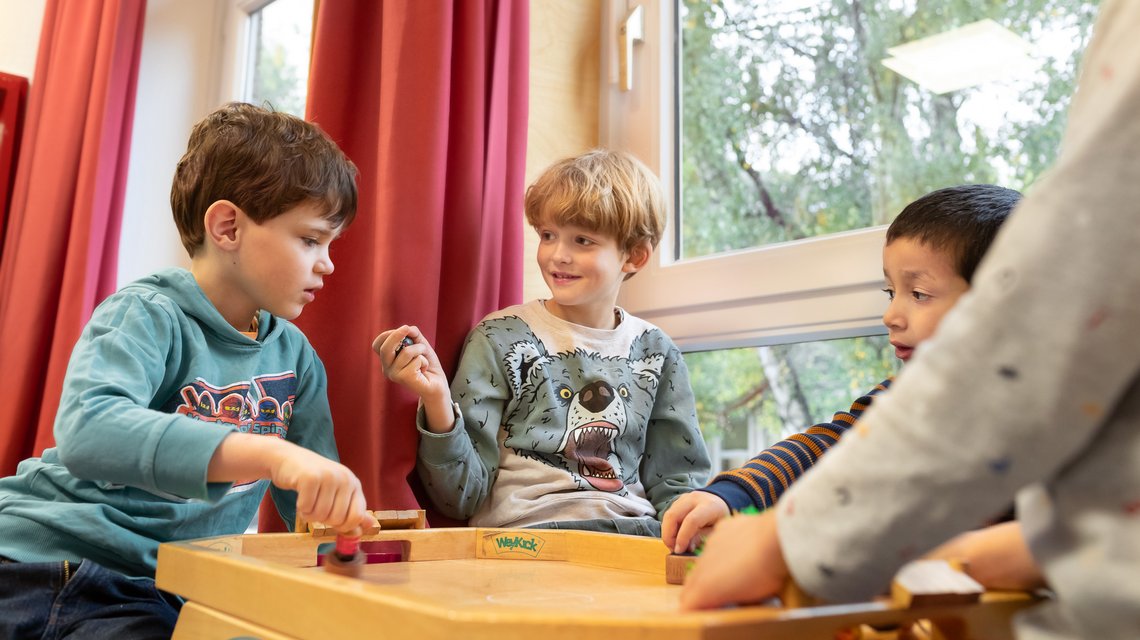 Grundschüler sitzen am Fenster und reden miteinander.